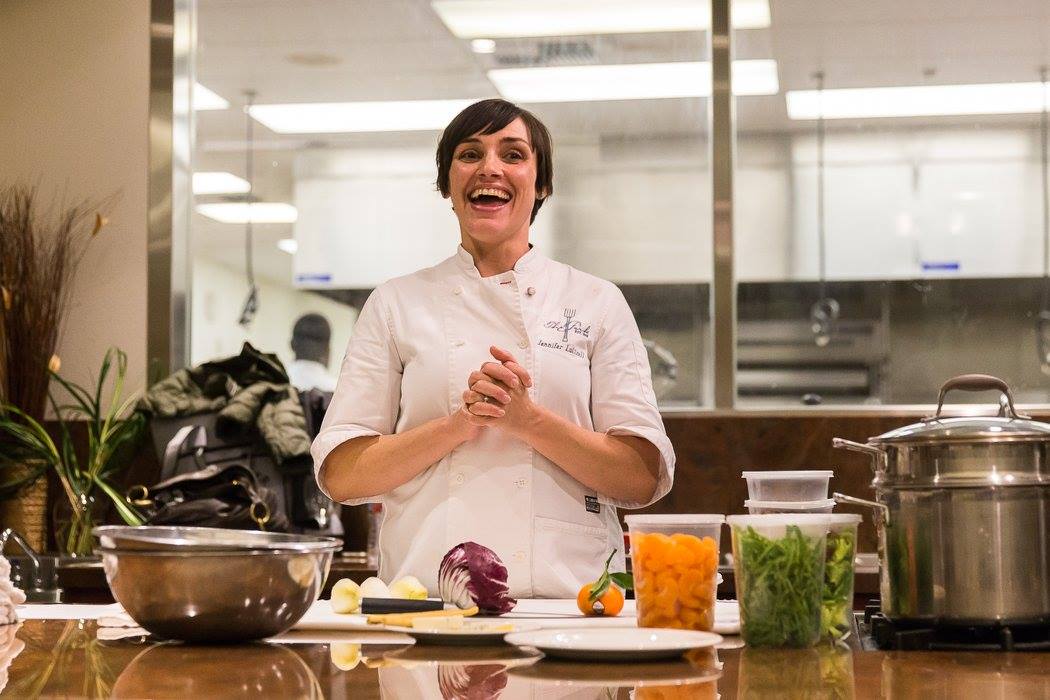 Chef Jennifer Luttrell smiling in front of kitchen in The Key Room located in Novato.