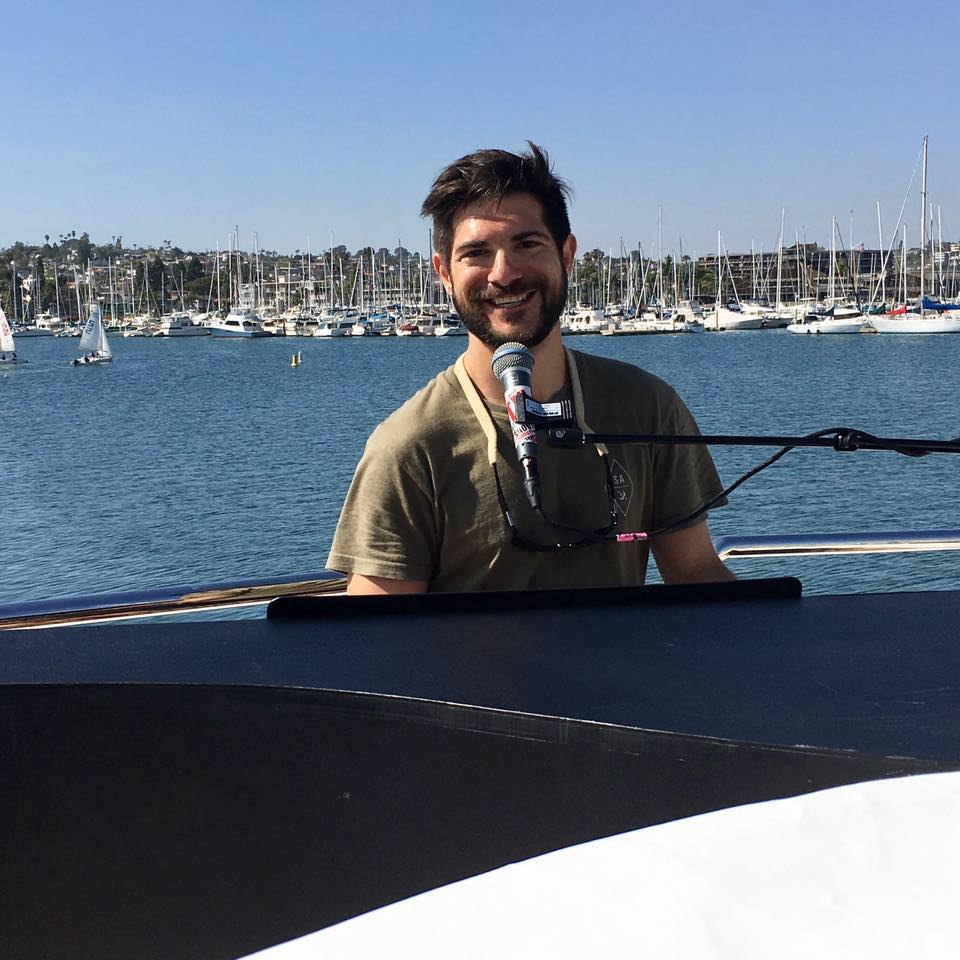 Pianist, vocalist and percussionist Jonny Greco smiling near Bay Area water