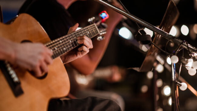 The musician plays and the lead singer sings on stage at the music festival at night.Concert,mini concert and music festivals.