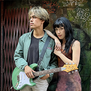 Live music couple Sophia and Trey standing together posing with guitar